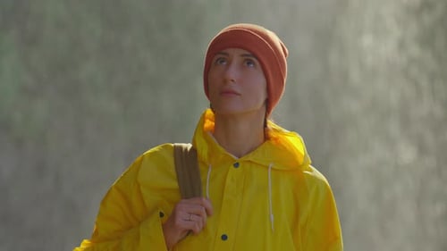 Woman in Yellow Raincoat Looking Upward