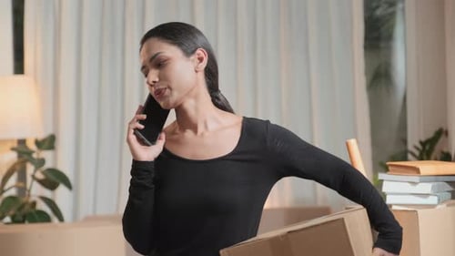 Woman Talking on Phone with Moving Boxes