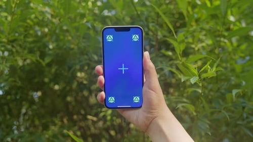 Young Woman Holding Phone Chroma Key Screen in Front of Green Trees in the Park Closeup Girl with