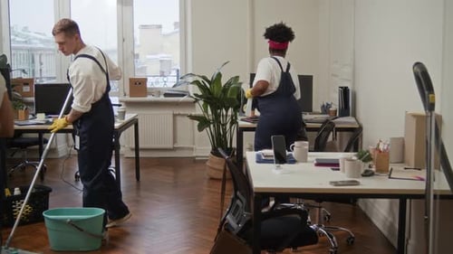 Concierges effectuant diverses tâches de nettoyage dans un bureau moderne
