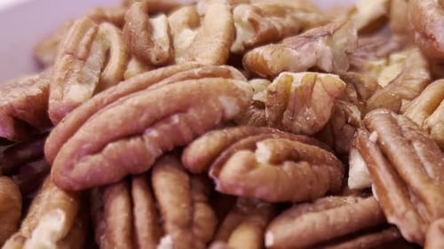 Pecan nuts filling frame creating healthy snack background, panning