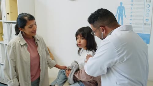 Doctor Examines Child with Mother in Office