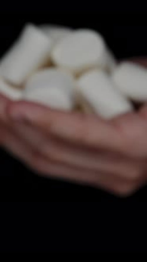 Vertical video. White Sugar Marshmallows in a Male Palm. Sugar Addiction. Offering Them to You.