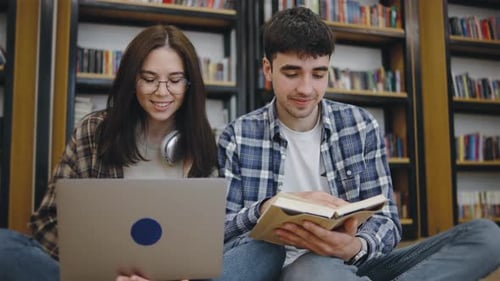 Young Adults Engaged in Study Session at a Library with Bookshelves and Cozy Atmosphere Showing