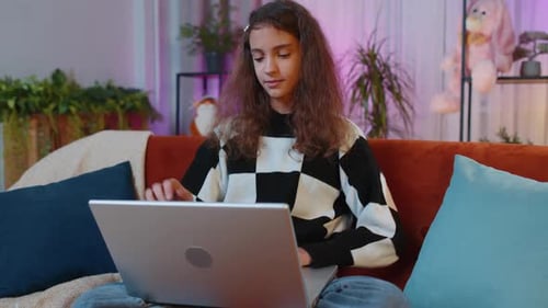 Junges freiberufliches Mädchen liegt auf der Couch und schließt den Laptop, nachdem sie die Arbeit im heimischen Wohnzimmer beendet hat