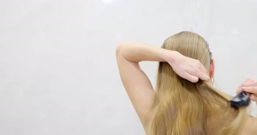 Woman Brushing Long Blonde Hair After Showering