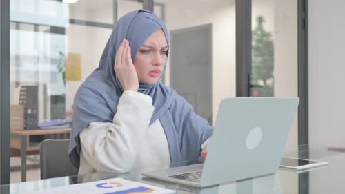 Woman in Headscarf Working at Laptop with Headache