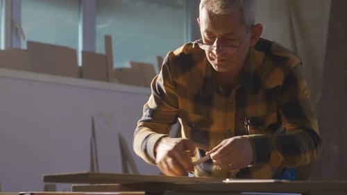 Adult Man Working with Wood in a Workshop
