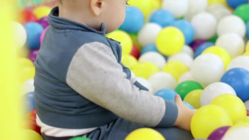 kids brothers baby preschooler boys playing in ball pit pool colorful soft plastic toys play center