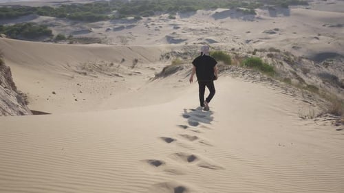 Alone in the desert, a man surrounded by golden sand