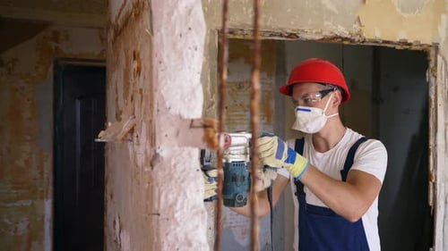 Focused Man Drilling in a Remodeled House
