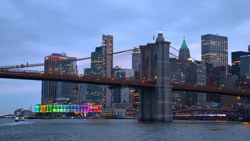 The Brooklyn Bridge at dusk time. Low angle view at the structure from the riverscape.