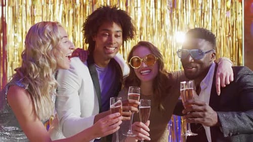 Friends Celebrating with Champagne Against Gold Backdrop