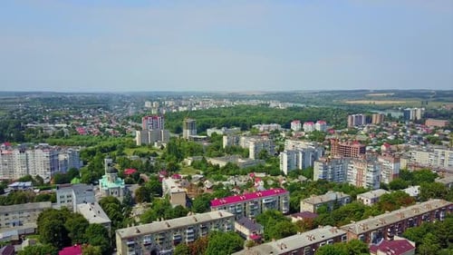 Vast cityscape on bright summer day. Ukrainian city full of greenery at daytime. Top perspective.