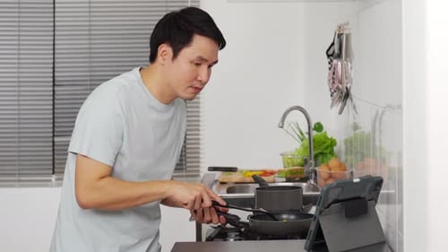 Man Cooking Healthy Meal Using Tablet Recipe