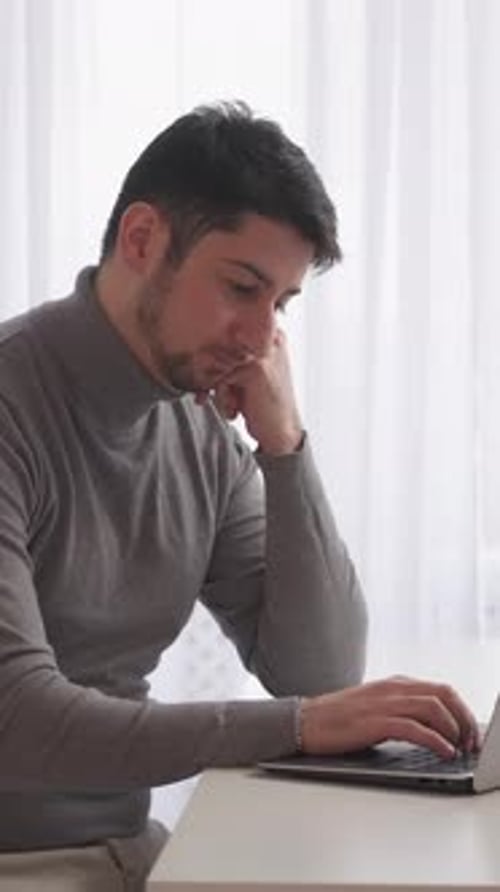 Man Typing on Laptop Computer at Desk