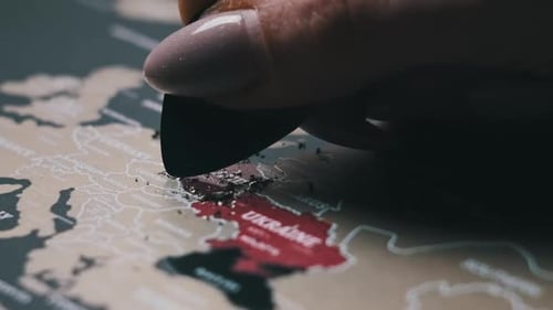 Woman Scratching Europe Countries on Surface of Scratch World Map in Slow Motion