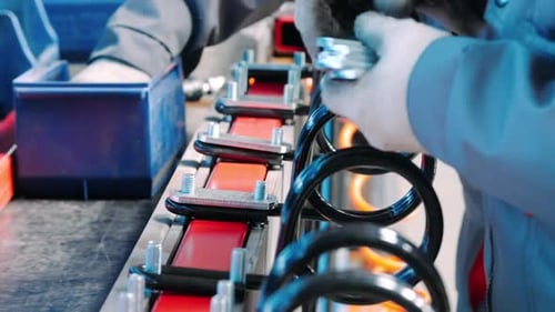 Worker Assembling Automotive Suspension Springs on Assembly Line