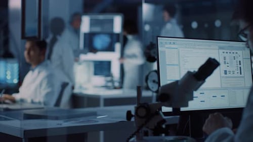 Scientists Analyzing Microscope Data in a Lab Setting