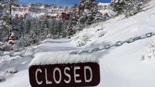 Closed Sign on Snowy Trail Revealing Winter Landscape