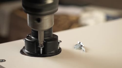 21v. Furniture legs are attached with a screwdriver. Assembling cabinet furniture.