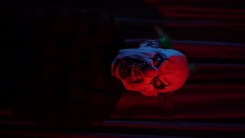Scary Clown Mask on the Floor in Red Light