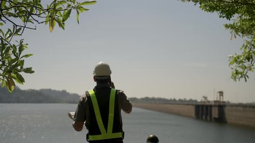 Blue collar worker is working at the dam.