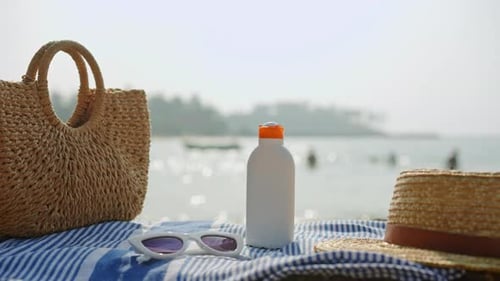 Beach Essentials On Sunny Seaside Day Trinkflasche mit Sonnenschutzfaktor und trendiger Strohhuttasche