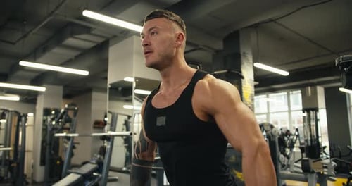 Muscular Man Powerfully Lifting Barbell in Modern Gym