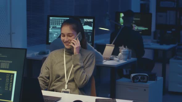 Female Programmer Talking on Phone while Working in Office at Night ...