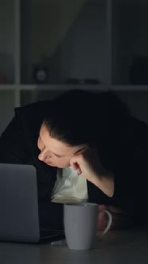 Tired adult Resting Head at Desk at Night