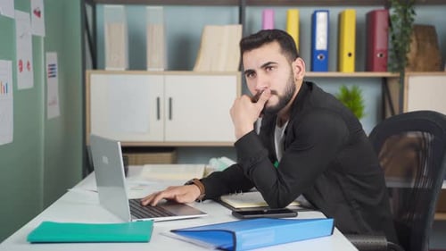 Young Adult Working on Laptop in Modern Office