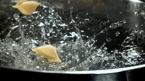 The Pasta Falls Into the Boiling Water with Splashes Filmed on a Highspeed Camera at 1000 Fps
