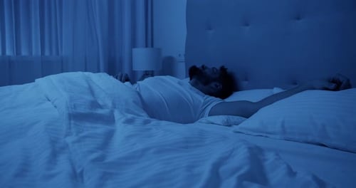 Sleepless Man Lying and Turning on Bed at Night