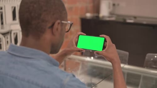 African Man Holding Phone with Chroma Key Screen
