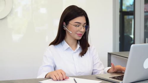 Woman with Headset Working at Computer