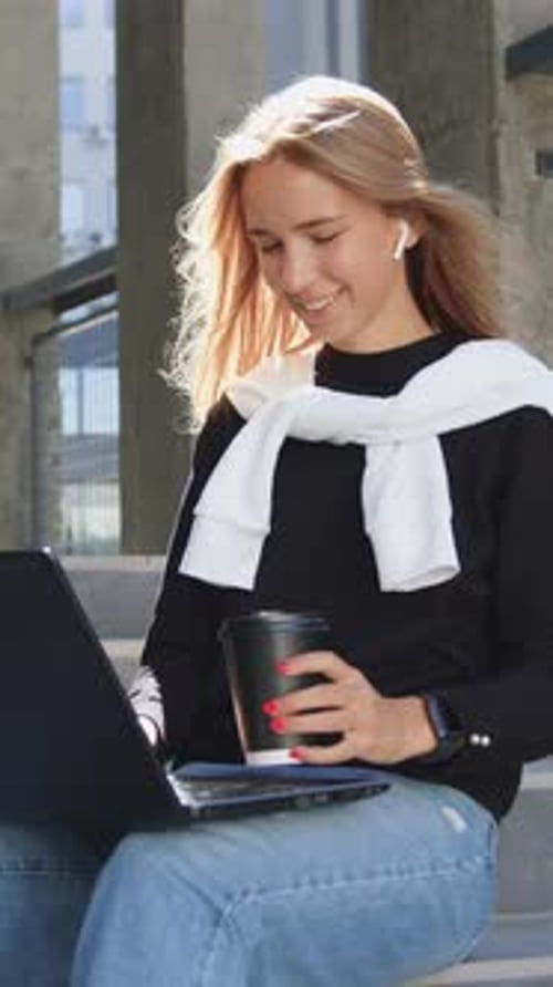 Lovely Joyful Contented Smart 2025Aged Blondie in Black Sweater and Jeans Resting on the Stairs of