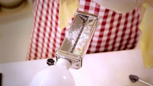 Pasta Maker Shaping Dough into Noodles in Kitchen