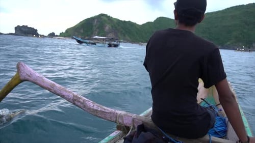 SLOW MOTION Man Sits on Bow of Southeast Asian Boat in Island Setting