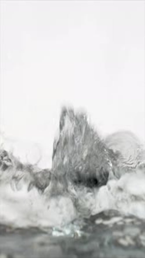 Water Pouring and Splashing Against a White Background