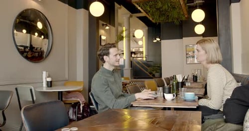 Young Adult couple having a good time together in cafe restaurant and drinking coffee