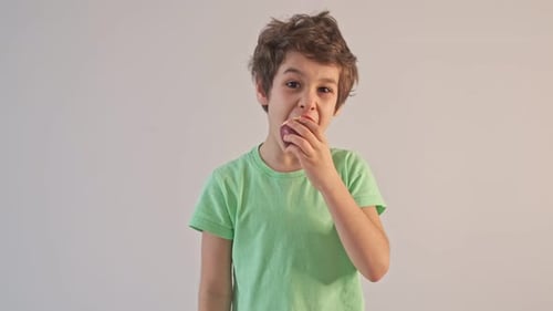Handsome Boy Eating Apple and Showing Thumbs Up