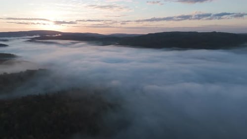 aerial scenic sunset above the clouds, drone fly above mountain landscape foggy misty sunrise