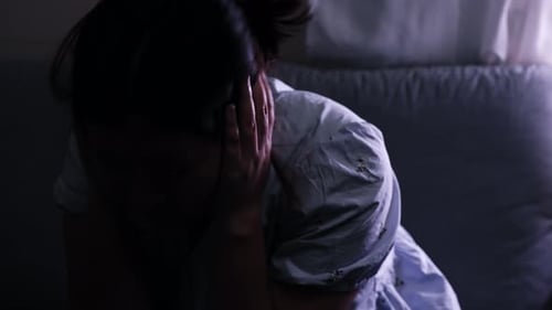 Scratching her head in desperation, a woman is filled with anxiety and showing signs of stress and d