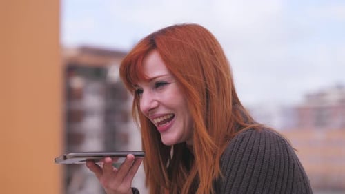 Red Haired Woman Using Voice Command on Phone