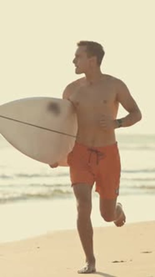 Surfer Running on the Beach with Surfboard