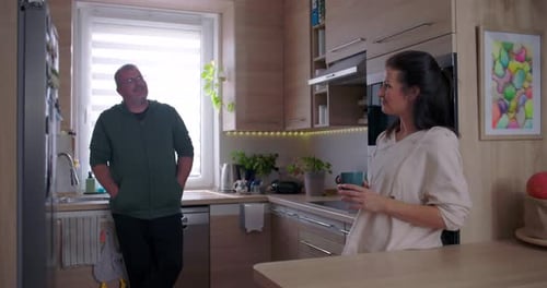 Adult Man and Woman Talking in Modern Kitchen