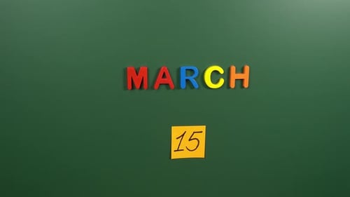 Hand sticking a sticker 15 March calendar day on school board. 15 date of March. Fifteenth day