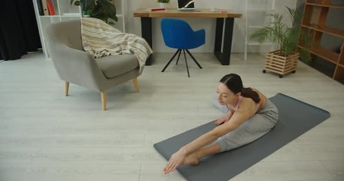 Woman Doing Stretching Exercises on Yoga Mat