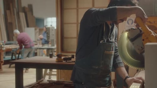 Man Using Chop Saw in Woodworking Shop